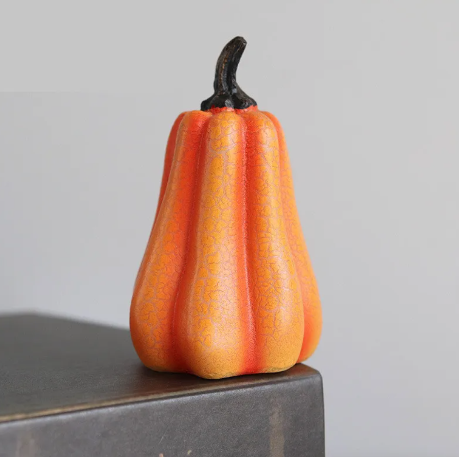 Tall crackle-glazed resin pumpkin with a dark stem on a grey box