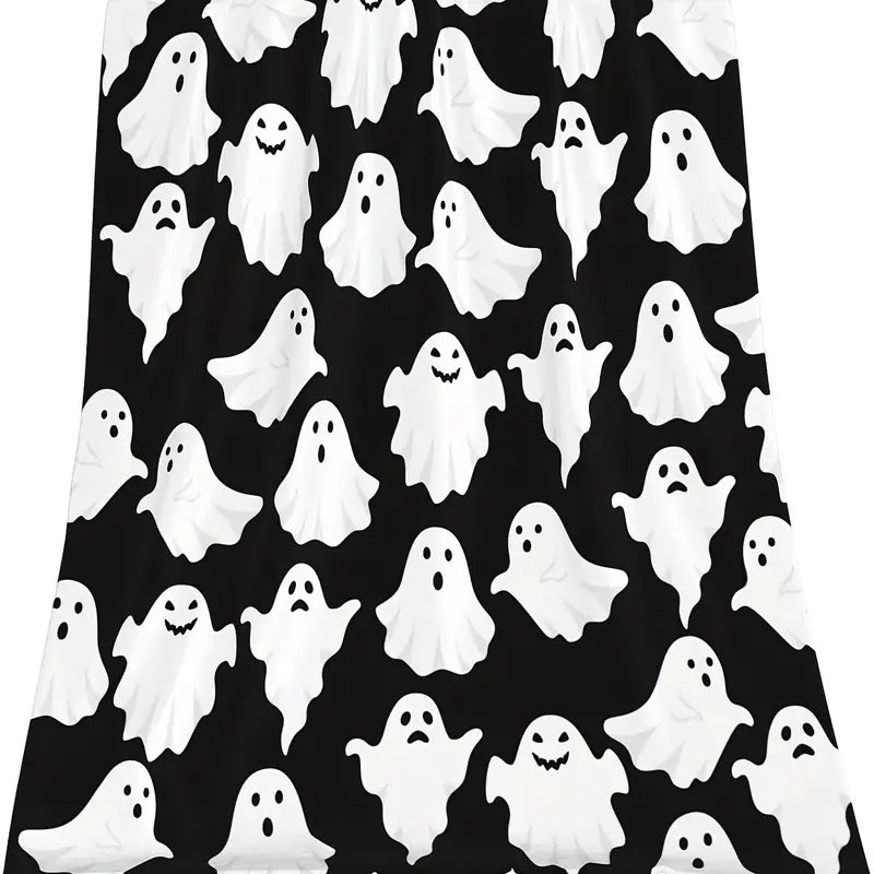 Full view of the black flannel throw blanket covered in small white cartoon ghosts