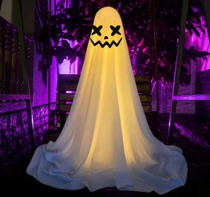 Hanging cloth ghost decoration with crossed X eyes and a jagged jack-o-lantern grin