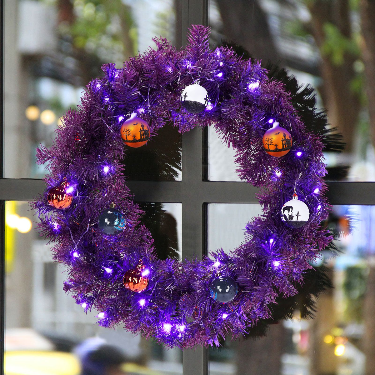 Close-up of the purple wreath lit with purple and orange LEDs on a window frame