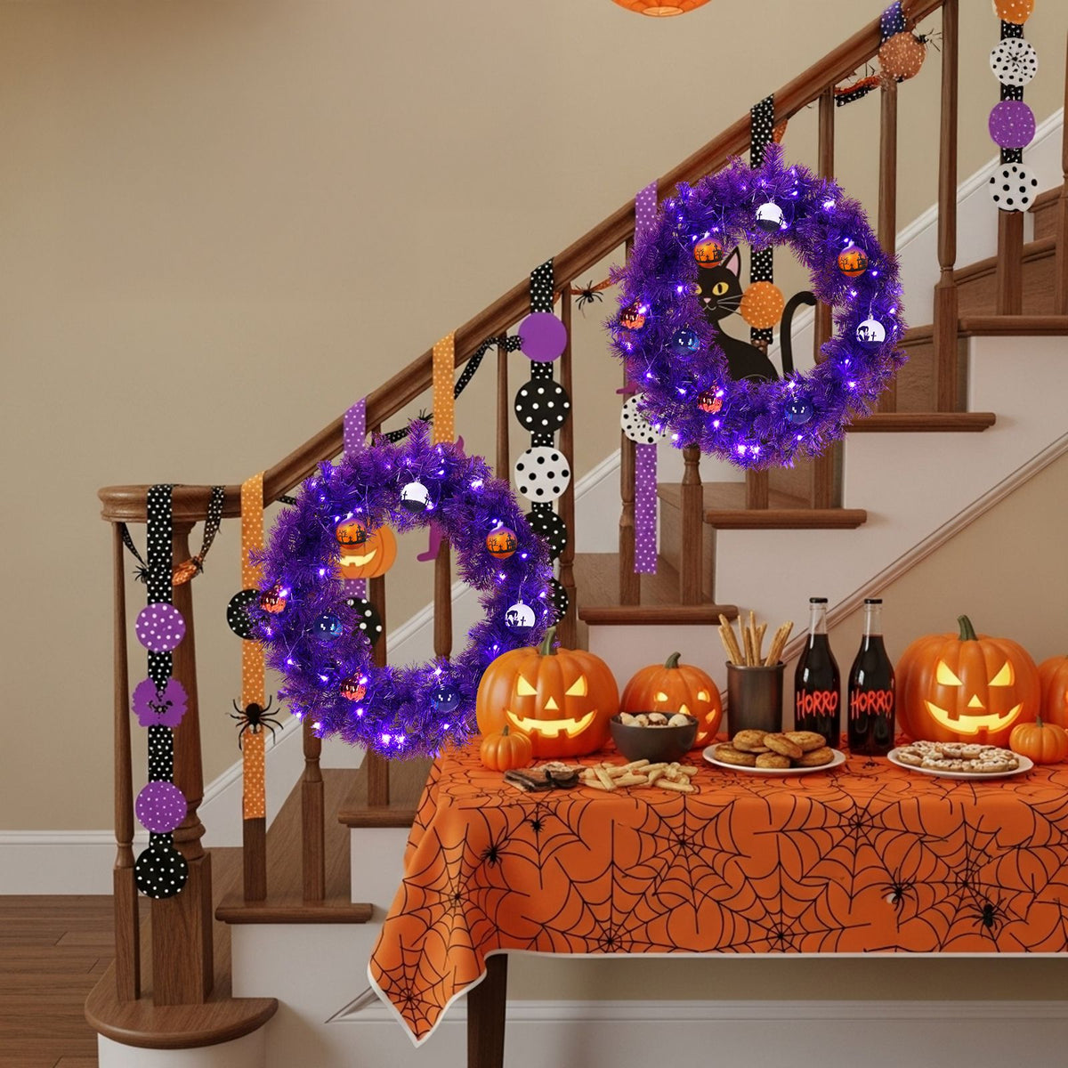 Purple light-up wreath hung on a staircase banister with pumpkins and a spiderweb tablecloth