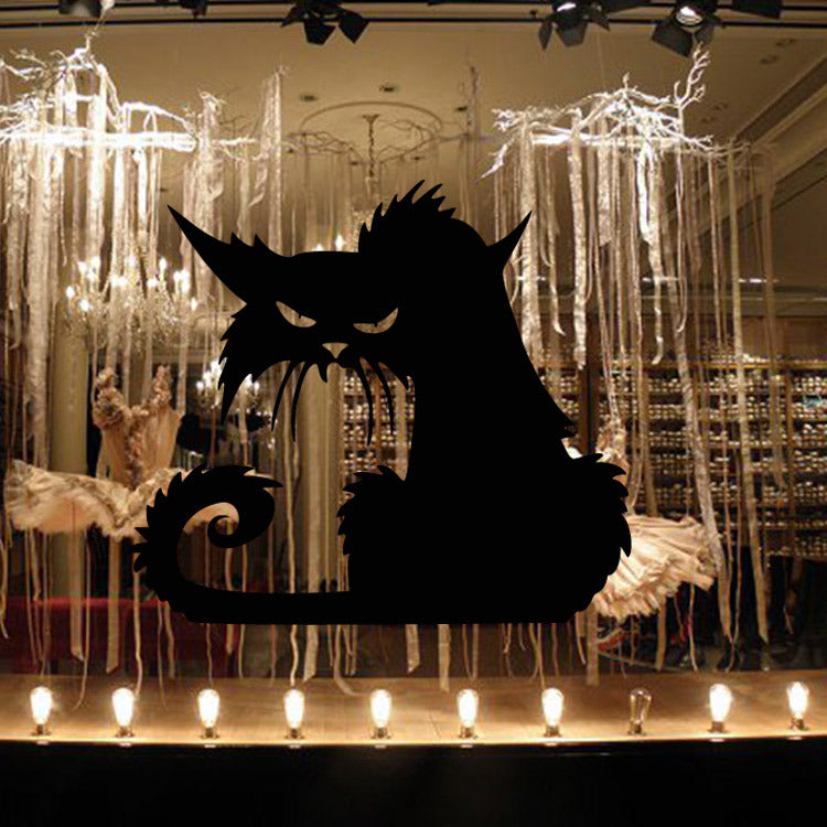 Black cat silhouette decal on a lit display window under chandeliers