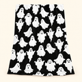 Black flannel throw blanket with white cartoon ghost print against a warm ivory background