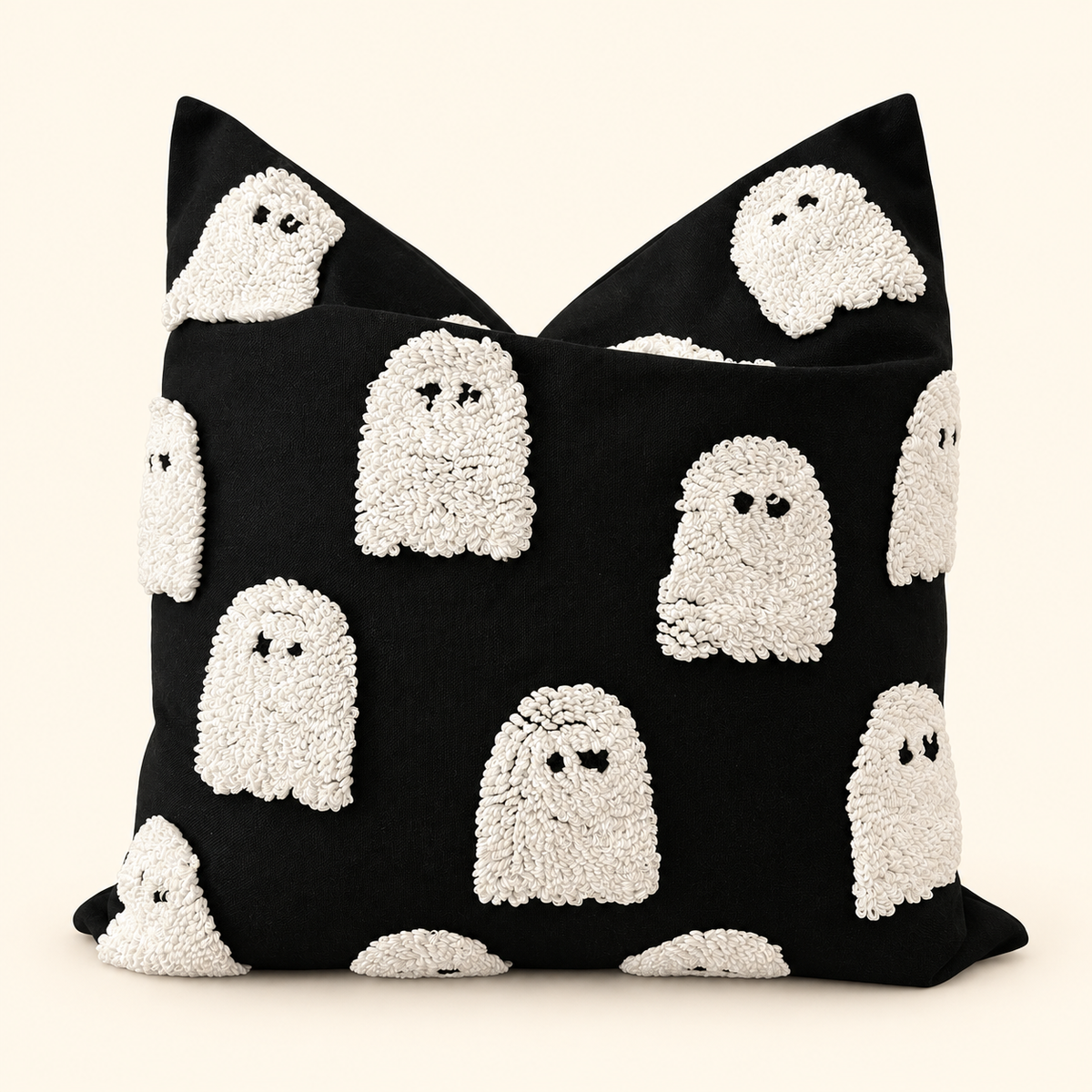 Single black pillow cover with cream tufted ghosts, styled on an insert against a warm ivory background