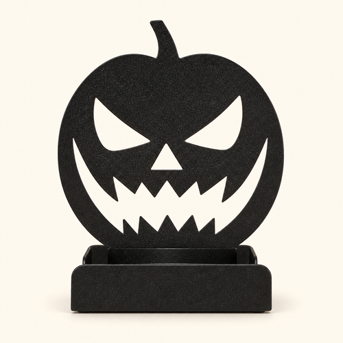 Black iron jack-o'-lantern silhouette tealight holder with folded base, shown without a candle on a warm ivory background